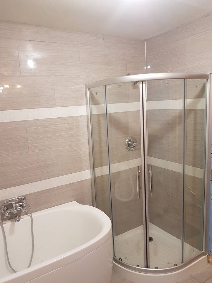 Bathroom renovation with tiled walls, soaker tub and glass corner shower
