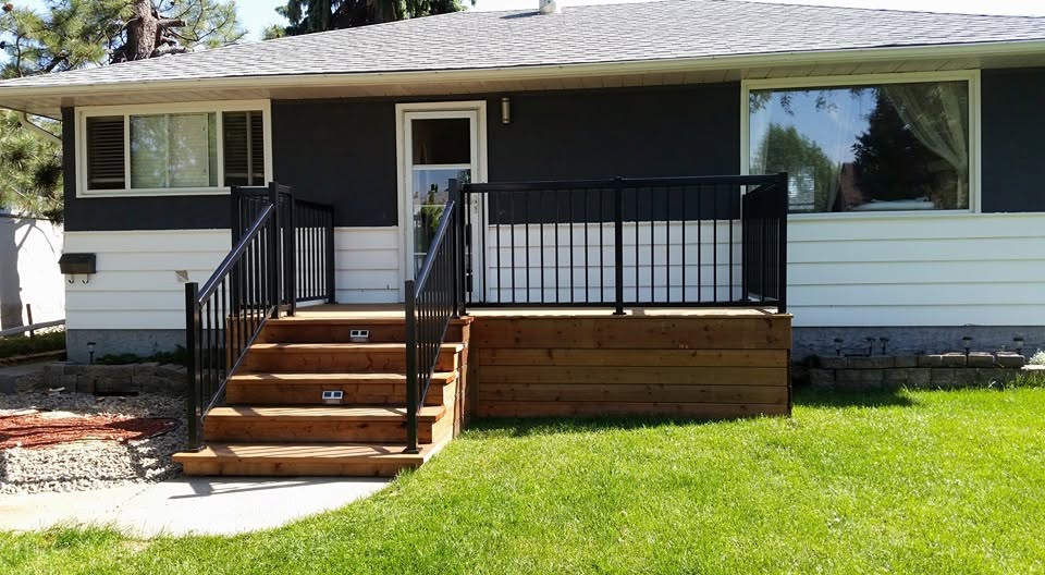 Front porch with black aluminum railing and cedar board skirting